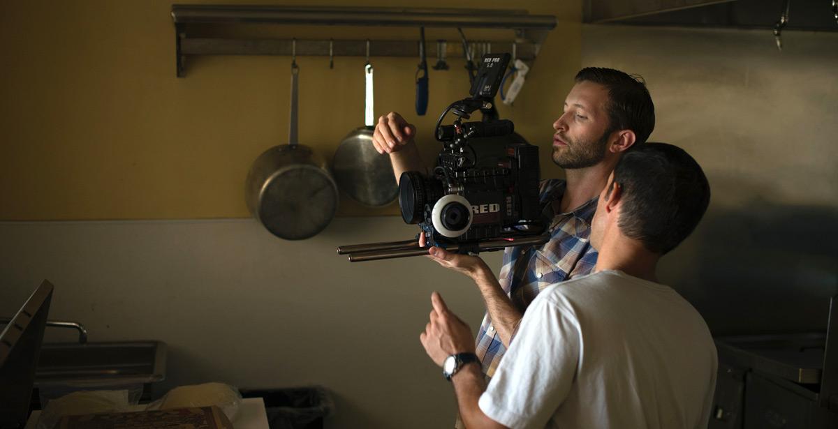 Due persone lavorano con la macchina da presa su set cinematografico - Photo by Mitch Nielsen on Unsplash