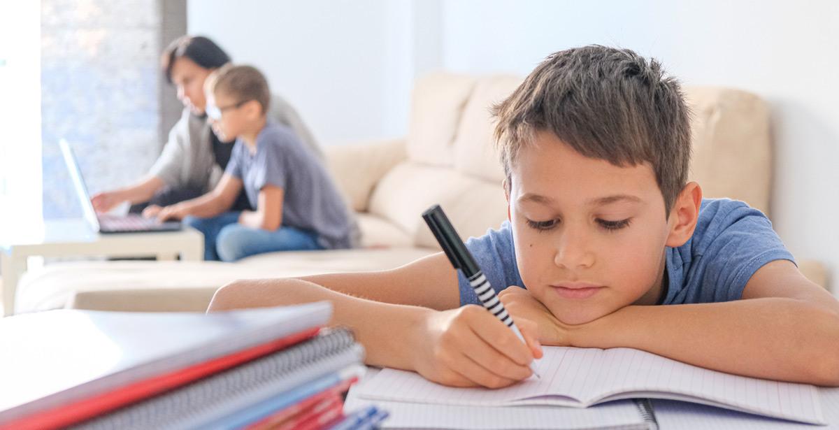 Bambini fanno compiti a casa con adulto - Foto di vejaa da Adobe Stock