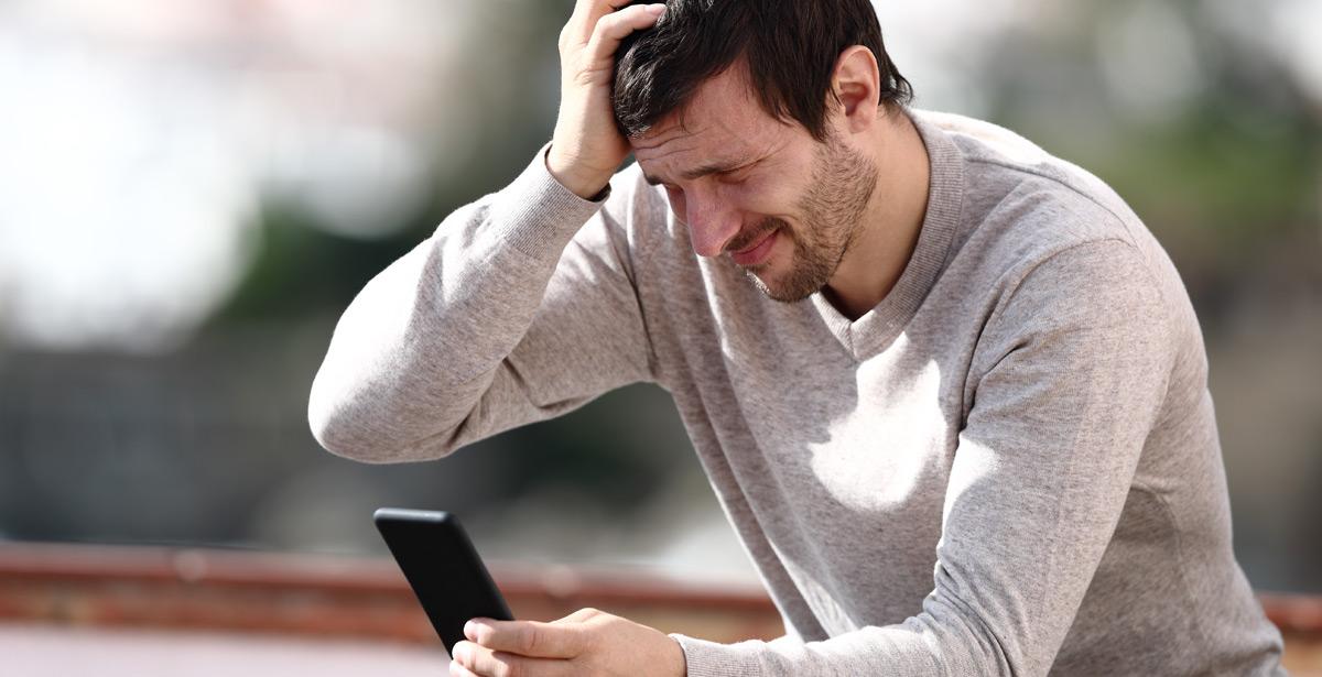 Uomo legge il cellulare con preoccupazione - Foto di Antonioguillem da Adobe Stock