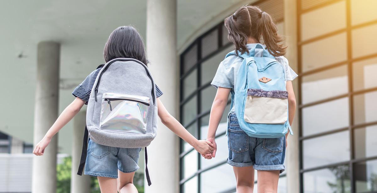 Due bambine entrano a scuola - Foto di Chinnapong da Adobe Stock