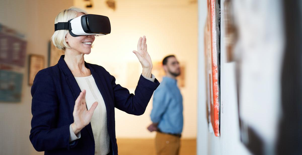 Donna visita un museo indossando una maschera da realtà virtuale - Foto di Seventyfour da Adobe Stock