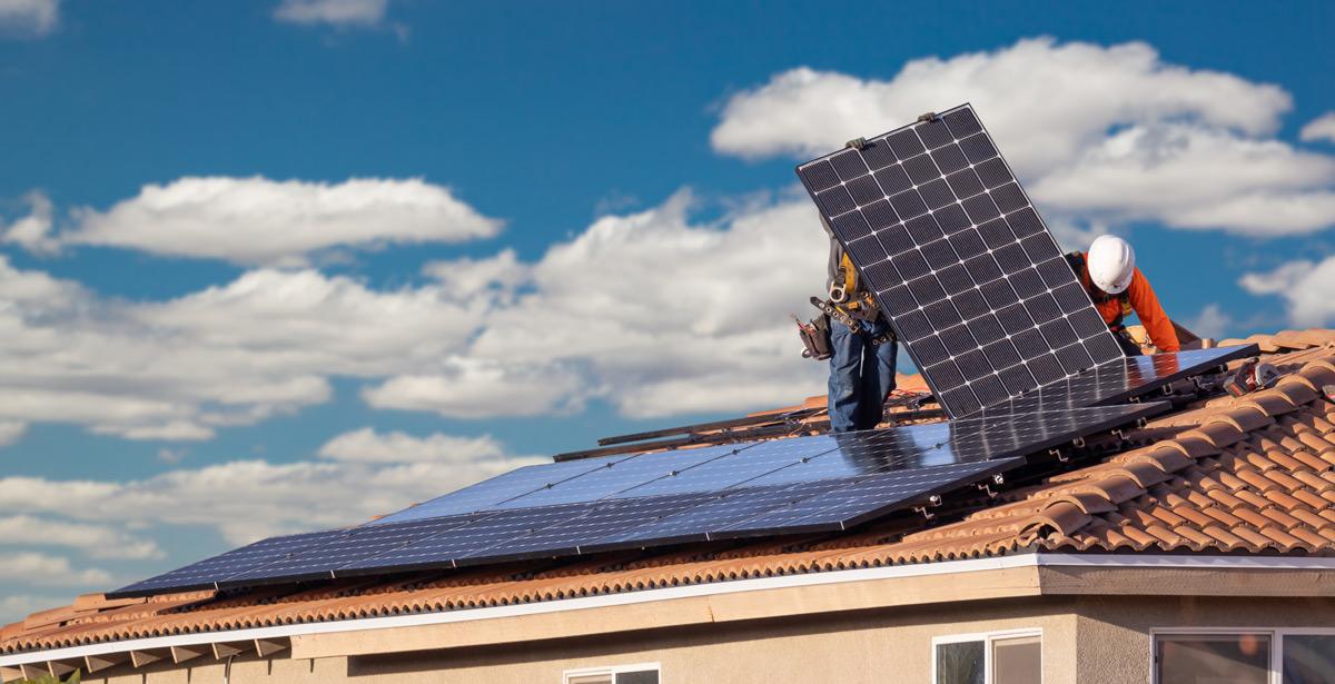 Operai installano pannelli solari sul tetto di una casa - Foto di Andy Dean da Adobe Stock