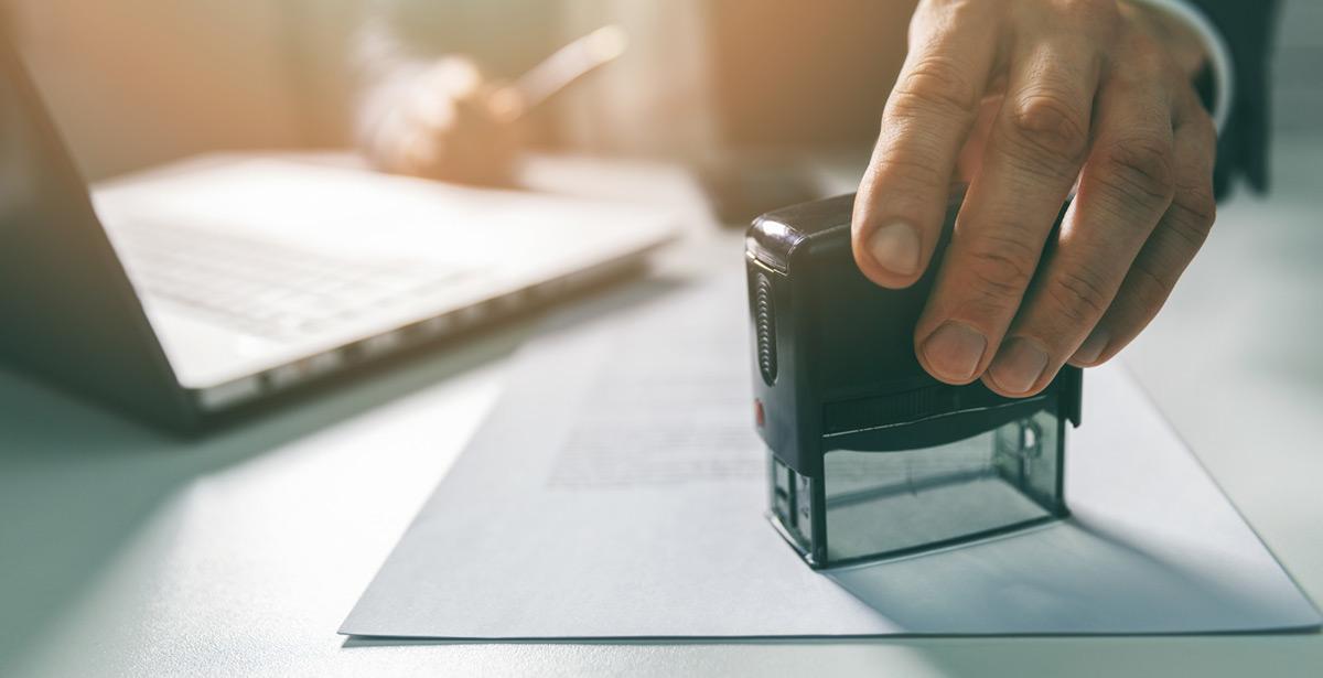 Impiegato pone timbro su foglio - Foto di ronstik da Adobe Stock