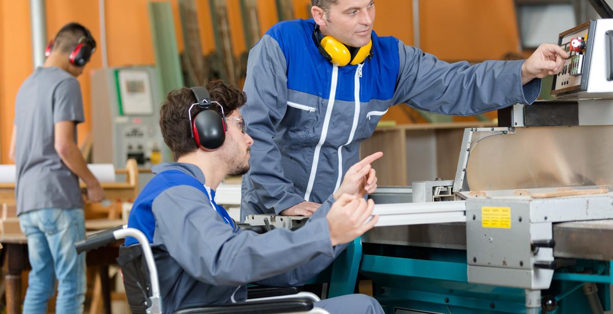 Ragazzo disabile al lavoro con supervisore - Foto di auremar da Adobe Stock