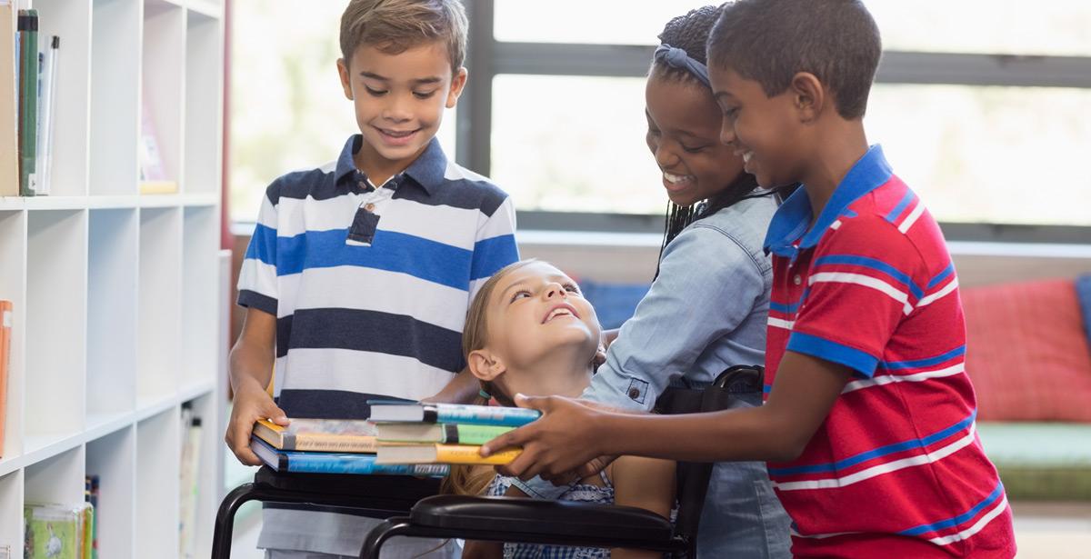 Bimba disabile riceve libri da compagni di classe - Foto di WavebreakmediaMicro da Adobe Stock