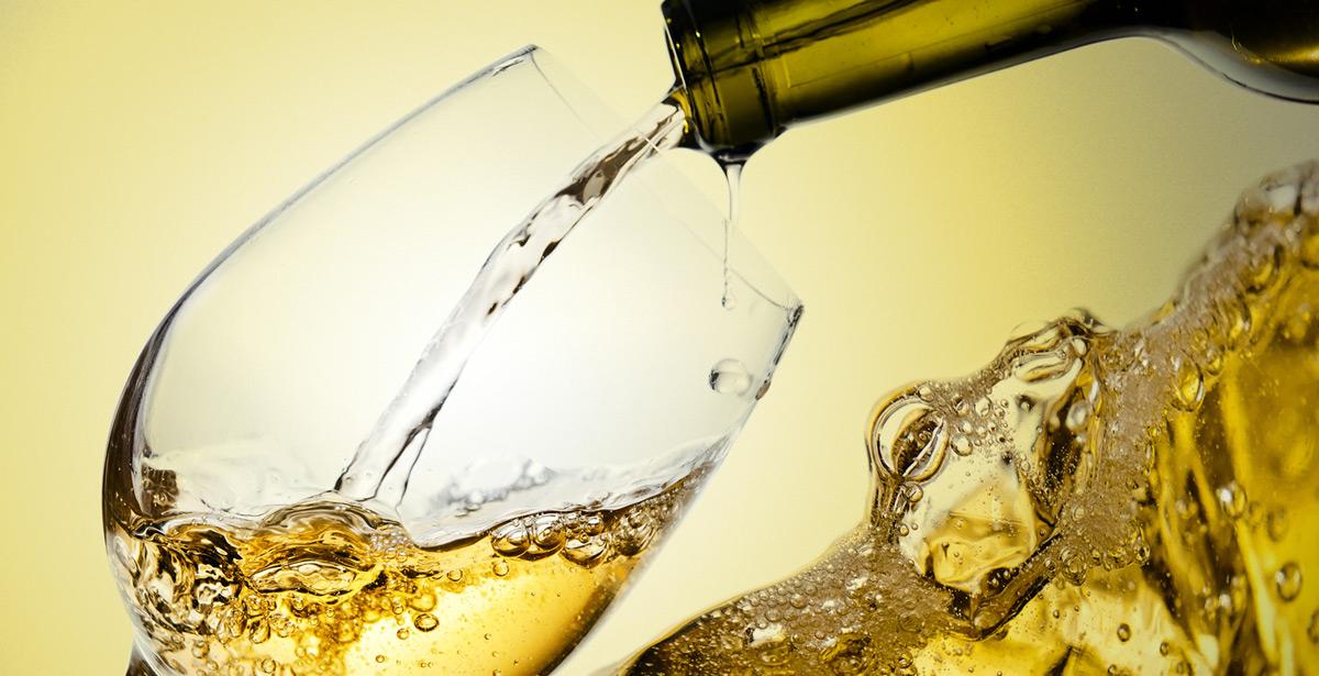 Vino bianco versato in un calice - Foto di Igor Normann da Adobe Stock