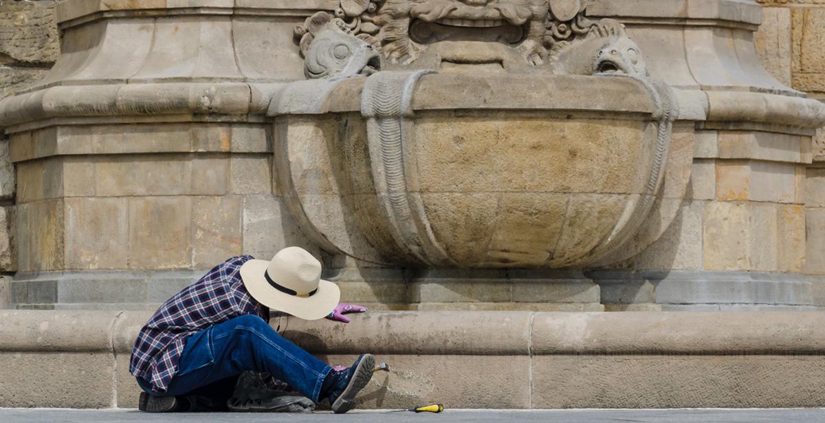 Volontario si dedica alla pulizia di un monumento - Foto di Wojciech Wrzesień da Adobe Stock