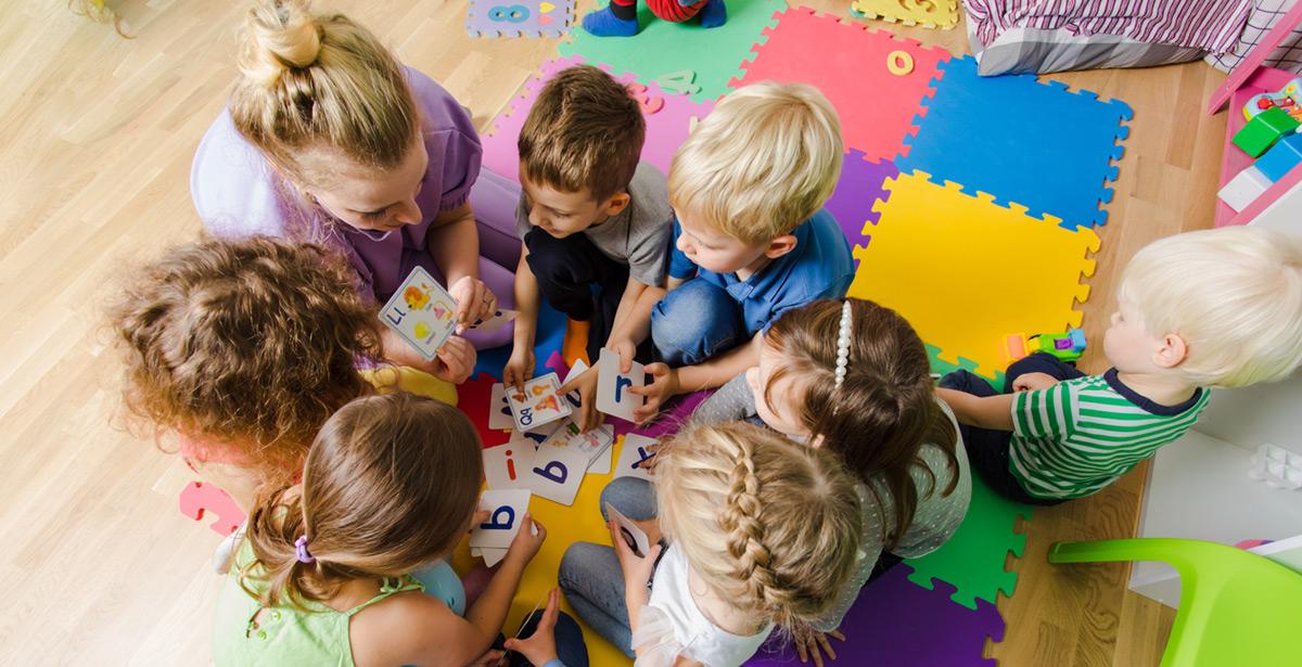 Bambini giocano al nido con l'educatrice - Foto di oksix da Adobe Stock