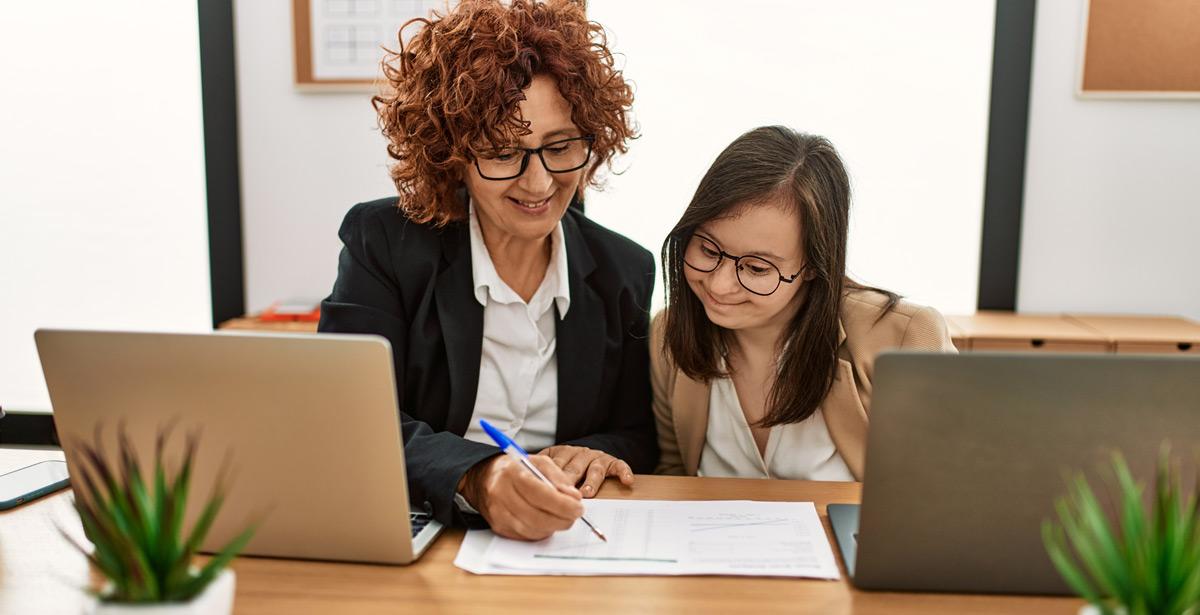 Impiegata aiuta ragazza in difficoltà a compilare moduli - Foto di Krakenimages.com da Adobe Stock