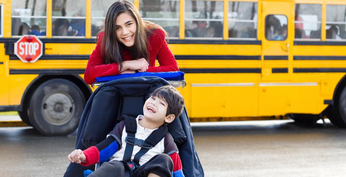 Giovane ragazza accompagna il fratellino disabile allo scuolabus - Foto di Jaren Wicklund da Adobe Stock