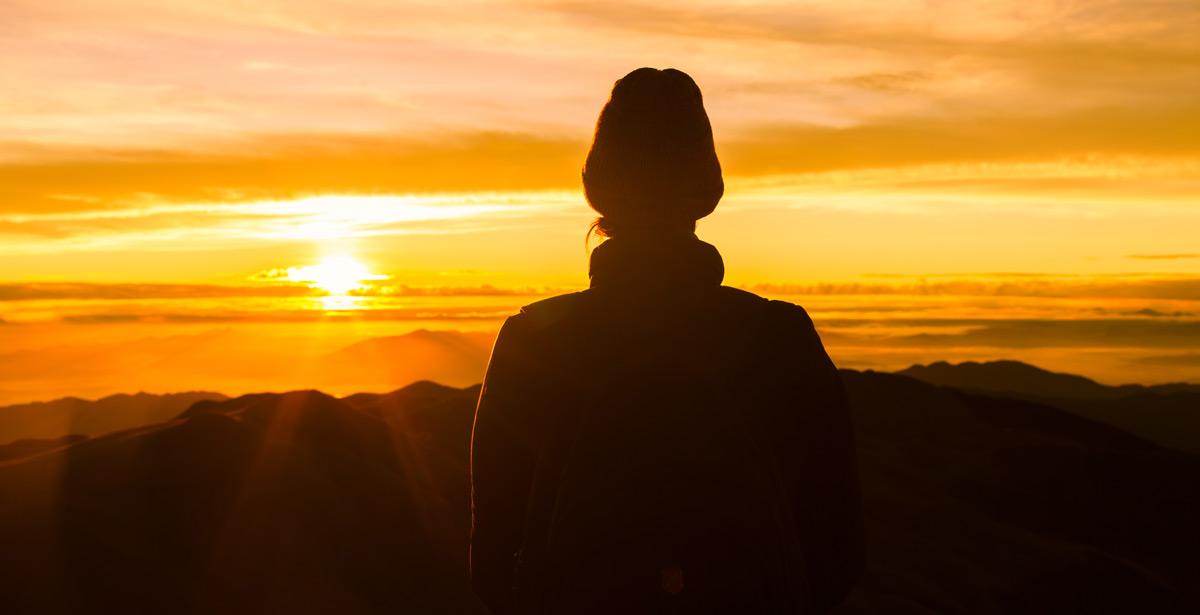 Donna osserva l'alba sulla montagna - Foto di kieferpix da Adobe Stock