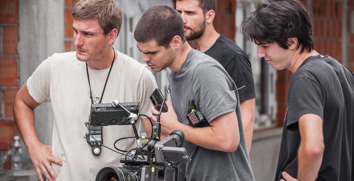 Troupe cinematografica controlla lo schermo durante le riprese - Foto di guruXOX da Adobe Stock