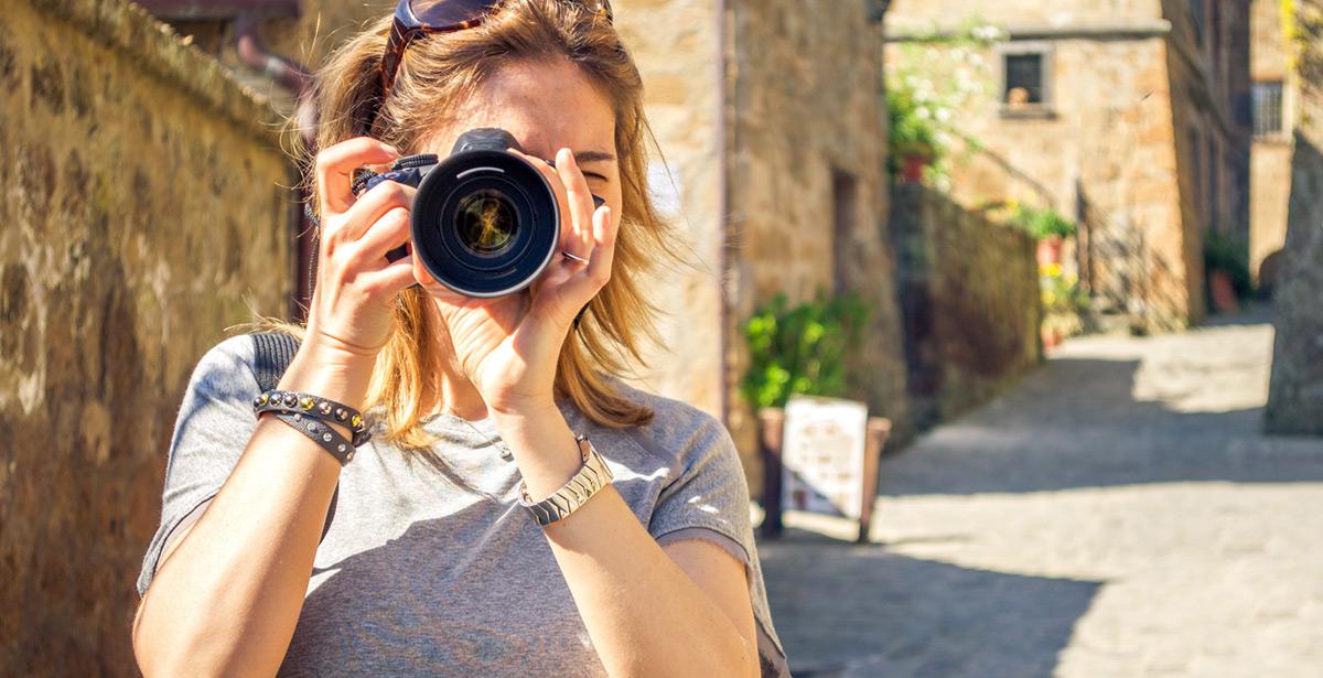 Una turista scatta foto tra le vie del borgo di Bagnoregio - Foto di Luca Lorenzelli da Adobe Stock