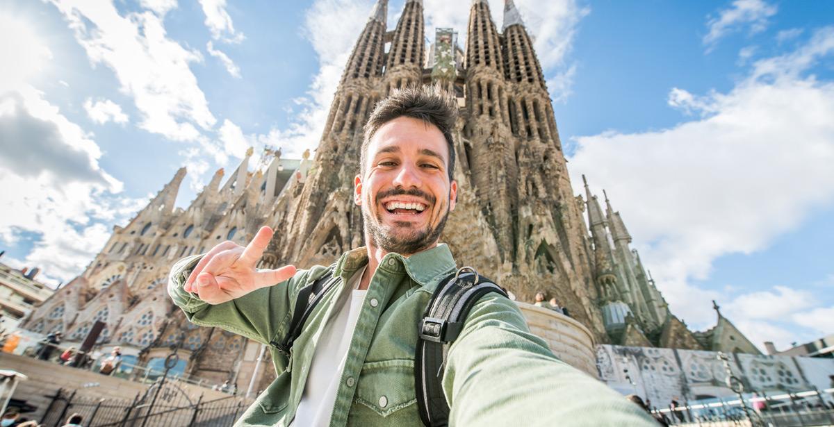 Giovane e felice si fa un selfie davanti la Sagrada Familia a Barcelona - Foto di Davide Angelini da Adobe Stock