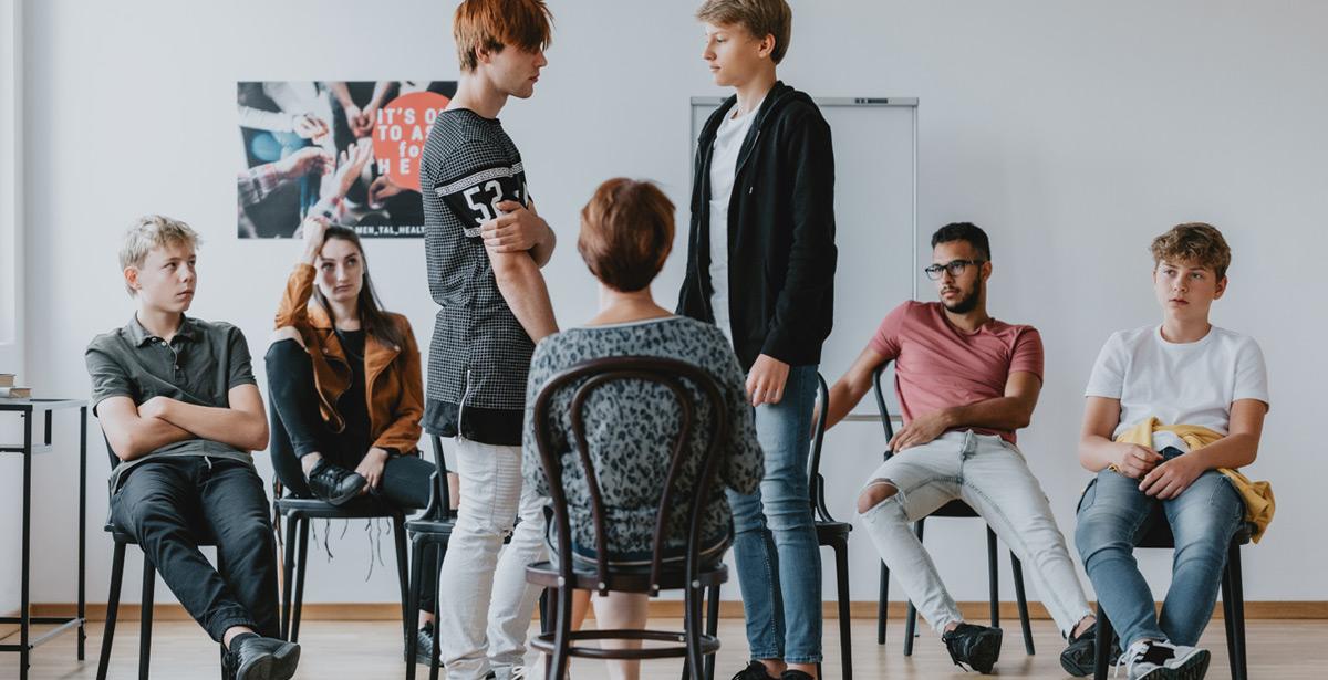 Gruppo di studenti a confronto da una insegnante - Foto di Photographee.eu da Adobe Stock