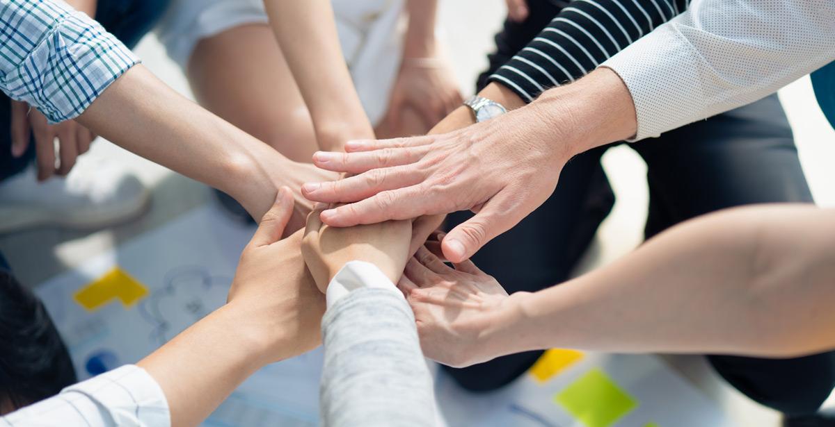 Gruppo di persone unisce le proprie mani in cerchio - Foto di ztony1971 da Adobe Stock