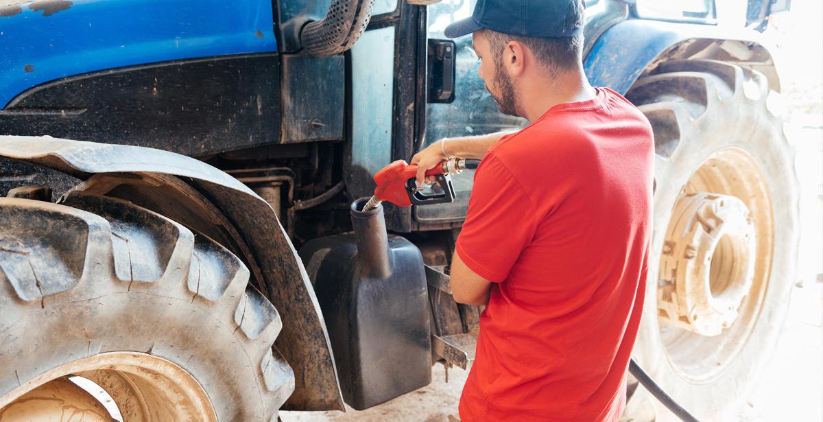 Giovane agricoltore rifornisce il trattore di carburante - Foto di Galdric da Adobe Stock